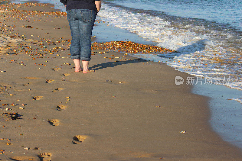沙滩上的脚印，海边的脚印，光着脚的女孩/腿